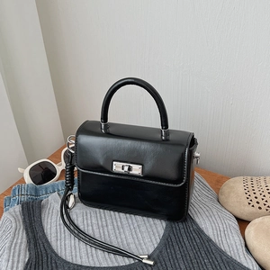 Detailansicht der schwarzen Retro-Handtasche mit silbernem Drehverschluss und glattem PU-Leder