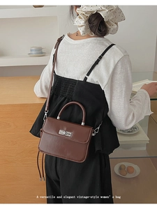 Rückansicht eines Models mit brauner Vintage-Umhängetasche und poliertem Silberverschluss