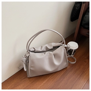 Détail du sac nuage gris clair avec cuir plissé et poignée à nœud élégante et moderne