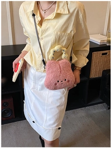 Close-up of pink plush cartoon crossbody bag with yellow handle and braided strap detail