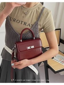 Details der burgunderroten Ledertasche mit silbernem Drehverschluss und Rundgriff