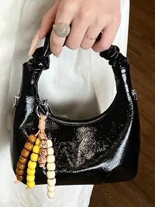 Glossy black pleated dumpling handbag with beaded charm and half-moon structure