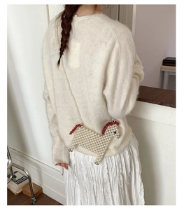 Détail du sac à bandoulière fait main en perles en forme de cheval porté par le mannequin