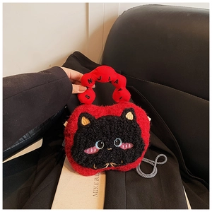 Detail of red plush handbag showing 3D black cat embroidery and braided red handle