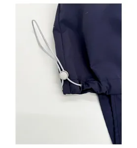 Detailed view of adjustable elastic drawstring and round lock on navy blue tote bag fabric