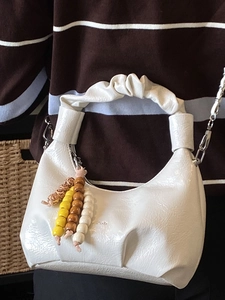 White pleated dumpling bag with beaded charm and silver chain strap for women