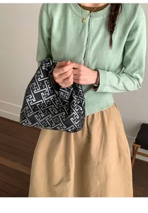 Vue détaillée de la texture jacquard géométrique noire et blanche du sac cabas d'épaule