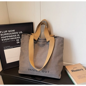 Detail view of large grey canvas tote bag with yellow straps and Inside Out print