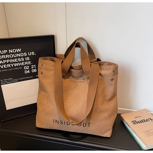 Close-up of brown canvas tote bag with INSIDE OUT text and large capacity interior