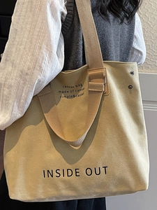 Large beige canvas tote bag with Inside Out print and wide shoulder strap for daily use