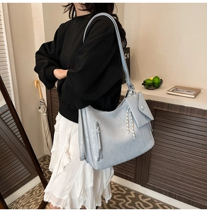 Détail du sac cabas bleu clair en cuir souple avec fermeture éclair et pochette assortie