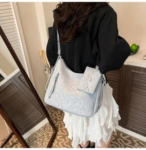 Détail du sac fourre-tout gris argenté en similicuir avec petite pochette assortie et bandoulière
