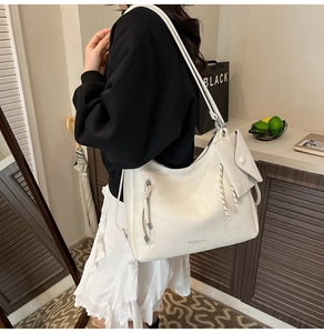 Détail du sac hobo en cuir blanc crème avec une petite pochette enveloppe et zip métallique
