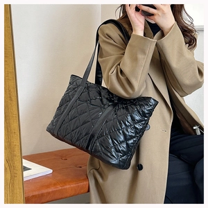 Gros plan du sac fourre-tout noir matelassé léger avec surpiqûres losanges sur un mannequin
