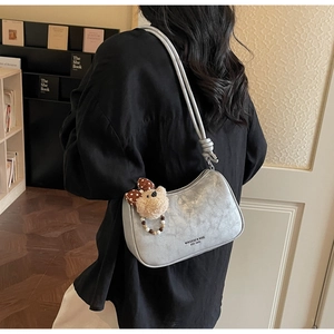 Detail of silver crescent shoulder bag with vintage PU texture and cute bear charm