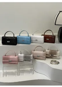 Details eleganter Handtaschen mit Krokoprägung in verschiedenen Farben und Metallschloss