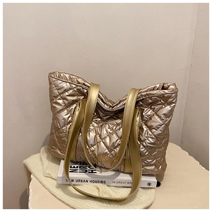 Détail du sac cabas matelassé doré champagne avec texture rembourrée et anses cuir