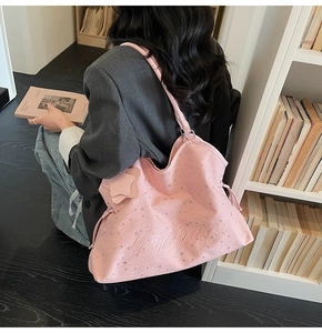 Sac fourre-tout rose avec étoiles argentées et cordon, porté à l'épaule par un mannequin