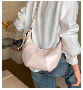 Detail of light pink crescent tote bag with textured faux leather and stylish chain