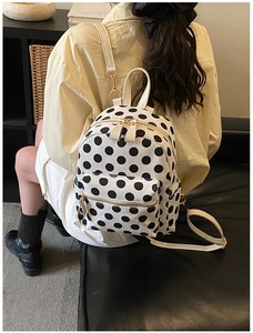 Detailed back view of a Japanese style polka dot backpack worn by a model in a studio