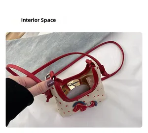 Detail of mini polka dot crossbody bag interior showing space for makeup and lipstick