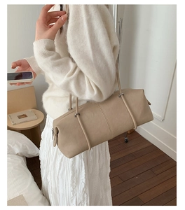 Detail view of beige leather tote bag featuring fine texture and elegant silver hardware