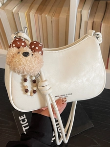 Chic beige crossbody dumpling bag with cute teddy bear charm and textured leather