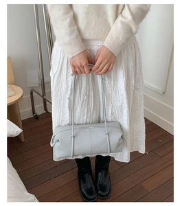 Detailed top view of the light blue cylindrical leather tote bag with long shoulder straps