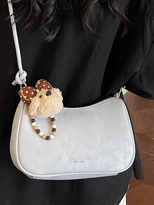 Minimalist light blue hobo bag with a cute plush bear pendant and beaded handle detail