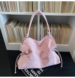 Détail du sac cabas rose imprimé d'étoiles avec cordons de serrage et breloque