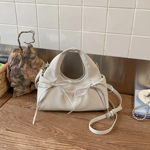 Detailed view of the pleated cloud bag featuring soft leather and chic ribbon bows