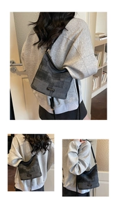 Détail de la bandoulière en cuir réglable et de la toile texturée de ce sac seau gris foncé