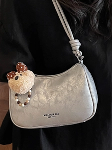 Silver metallic dumpling bag with logo print and teddy bear charm for women
