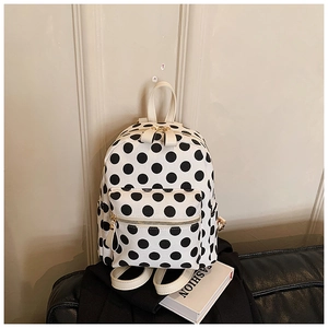Detail of trendy polka dot backpack with gold zippers and leather texture on a seat