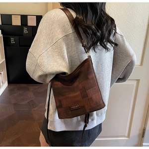Détail du sac seau vintage marron avec motif géométrique et bandoulière en cuir