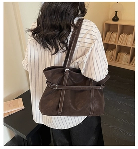 Detail view of vintage dark brown tote bag with white stitching and decorative straps