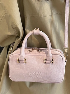 Pink suede crossbody handbag with gold hardware and Rosy Dodenia embossed logo