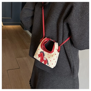 Close-up of mini polka dot crossbody bag featuring a 3D red pony embroidery detail