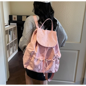 Back view of pink canvas backpack with silver star print and drawstring closure