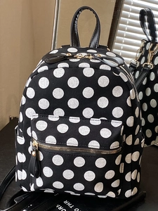 Minimalist black polka dot canvas backpack with golden zippers and leather handle for women