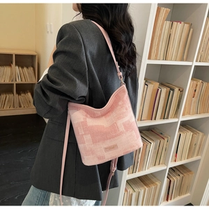 Détail du sac seau en jacquard rose à motif géométrique et étiquette logo en cuir