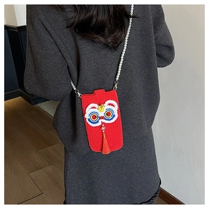 Detail of red crochet lion dance phone bag with pearl strap and fringe decoration