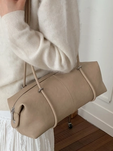 Chic beige cylinder tote bag with long shoulder straps in a minimalist Korean style