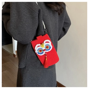 Detail of handmade crochet lion dance bag with pearl strap and long red tassel