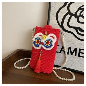 Detailed view of handmade knitted lion dance bag with pearl strap and red silk tassel