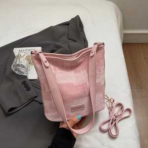 Détail du sac seau imprimé rose avec clous dorés et bandoulière réglable pour femmes