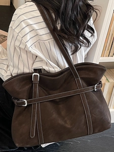 Vintage dark brown leather tote bag with white stitching shown on model in room