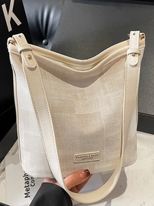 Sac seau chic en crème avec texture en tissu et bandoulière en cuir pour femme
