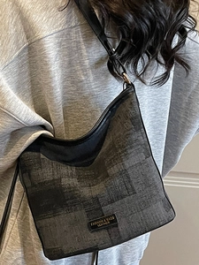 Sac seau gris foncé tendance avec texture géométrique et bandoulière noire élégante