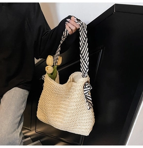 Détail du sac cabas en paille tissé main avec nœud et bandoulière en sergé noir et blanc